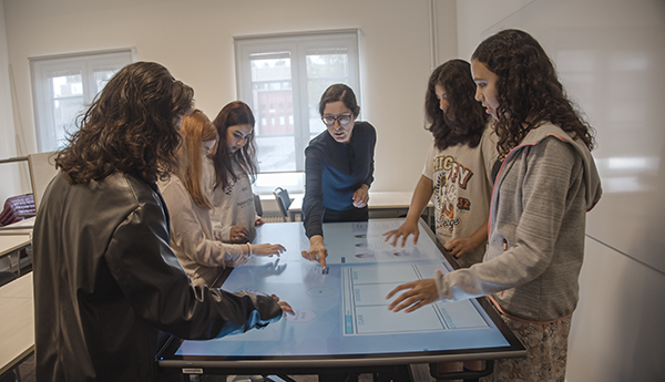 Students and teacher around touchscreen